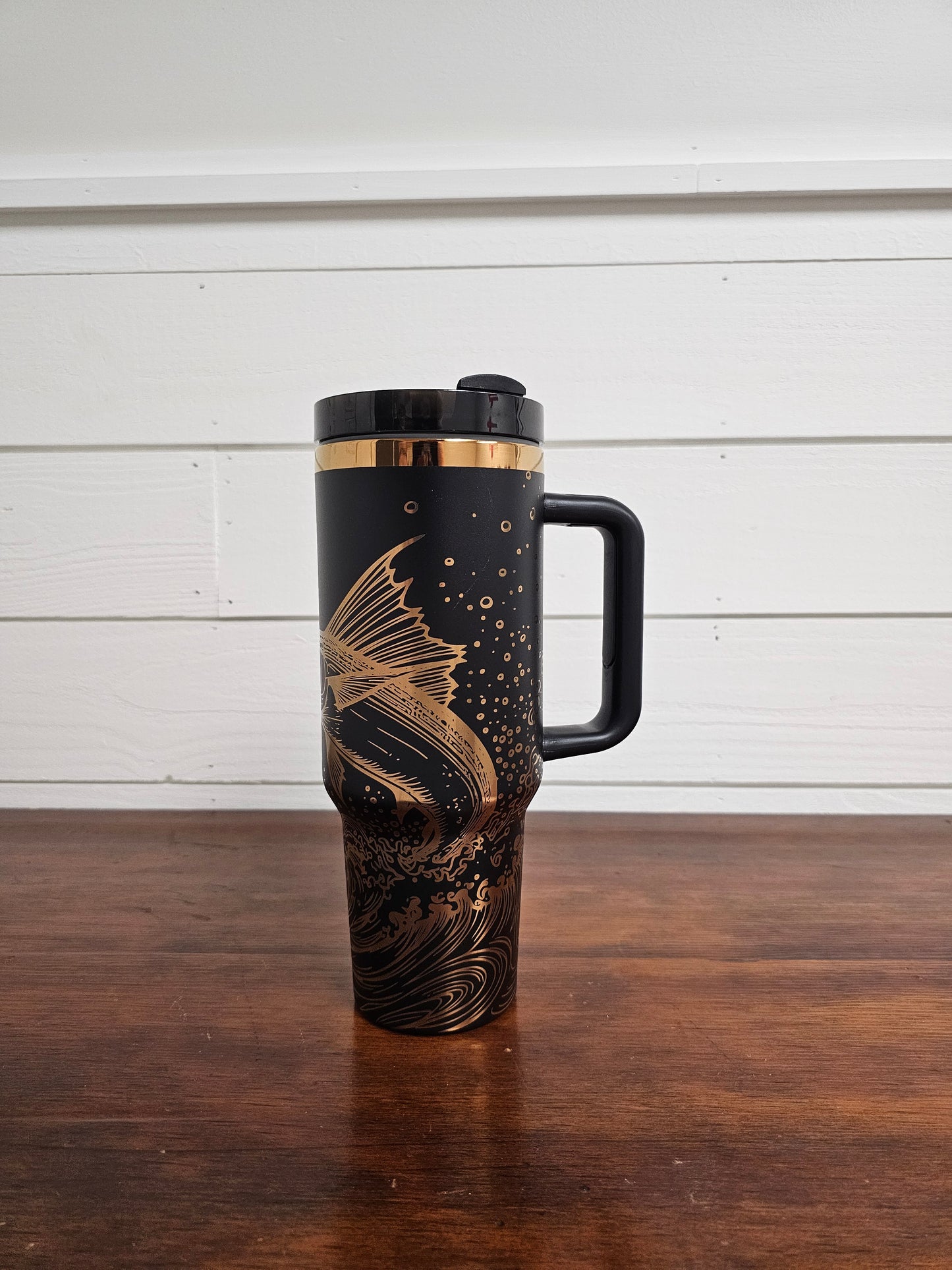 Laser engraved black and copper 40oz stainless steel tumbler with white marlin leaping out of the ocean.