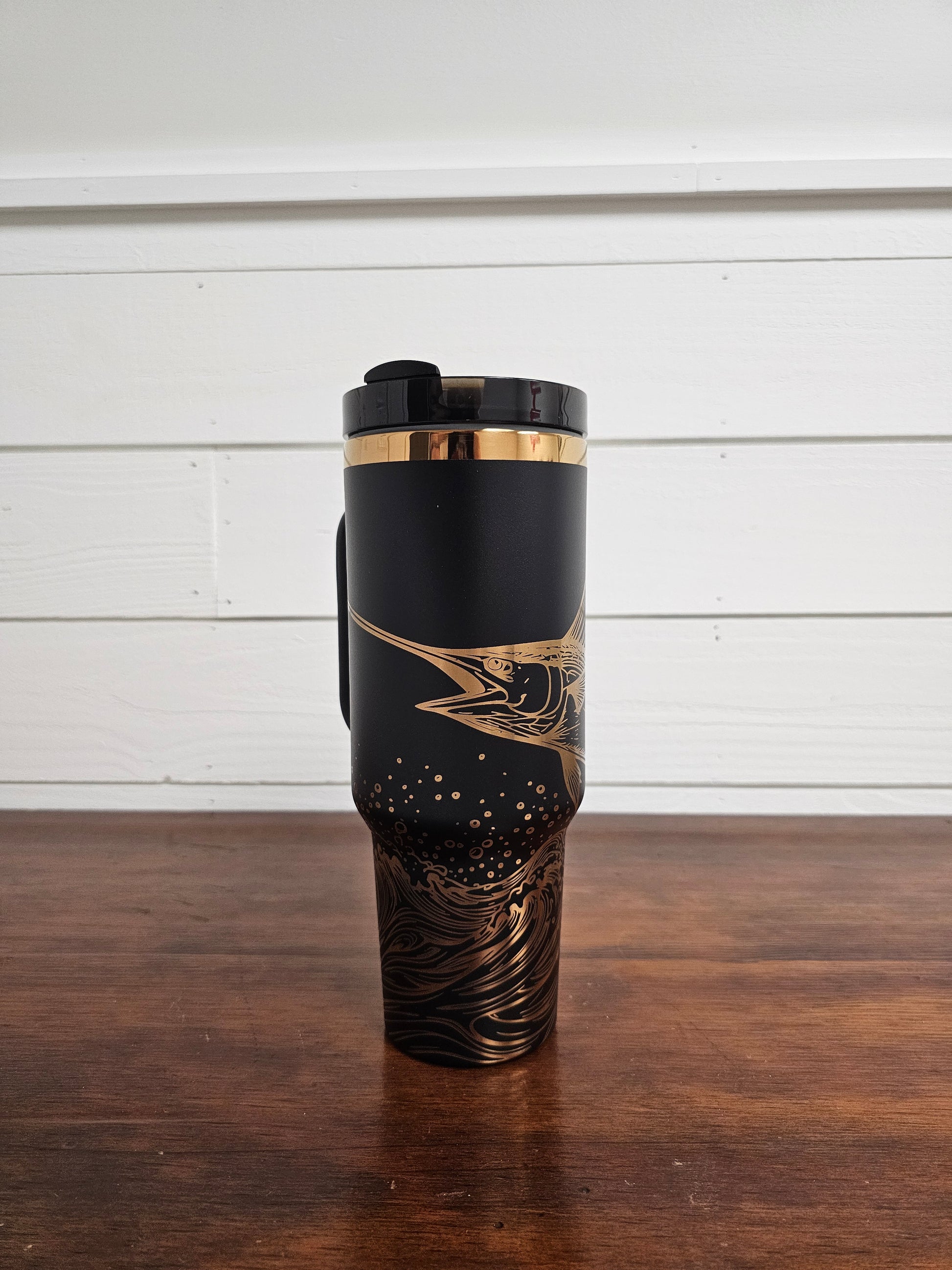 Laser engraved black and copper 40oz stainless steel tumbler with white marlin leaping out of the ocean.