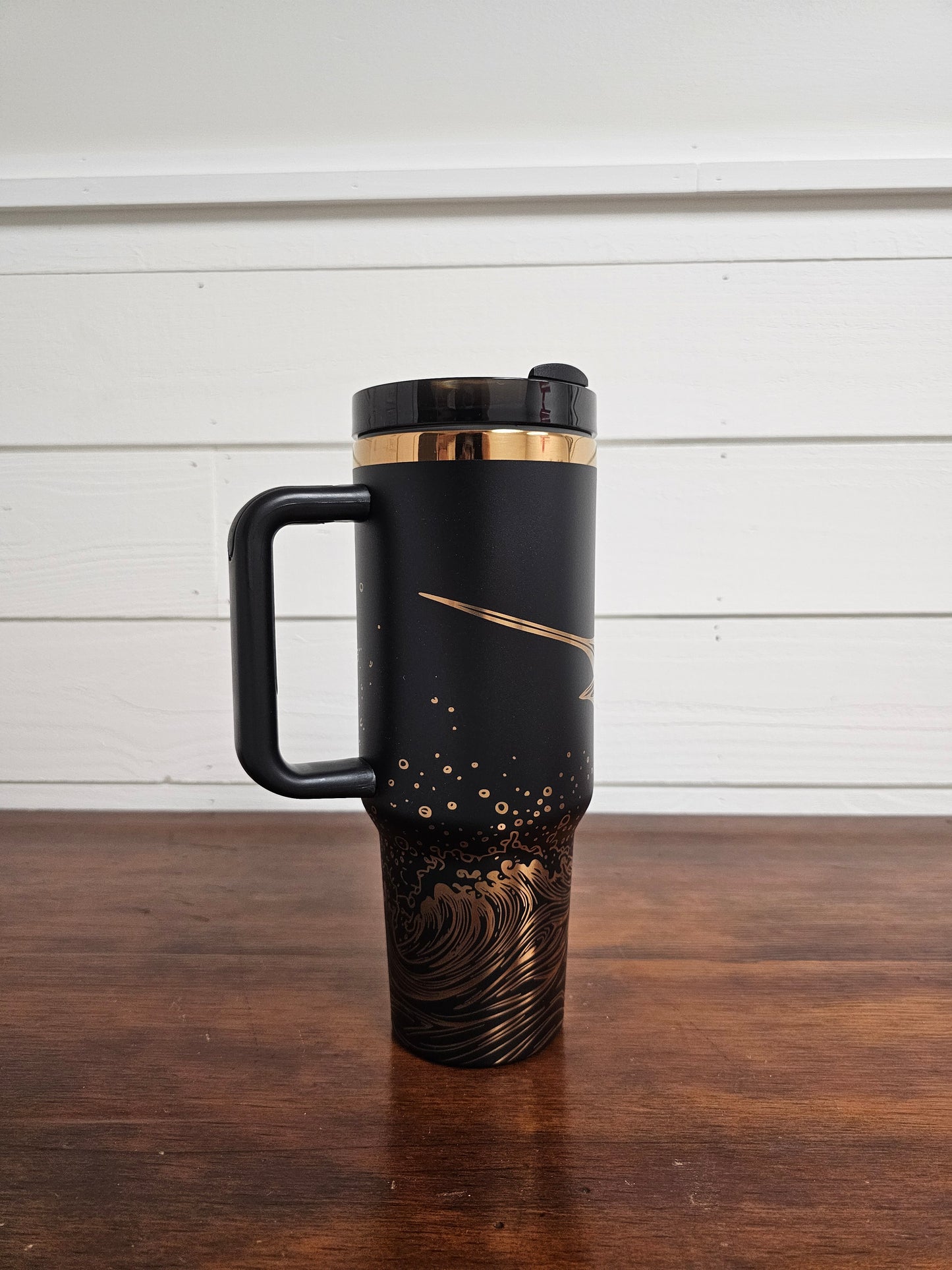 Laser engraved black and copper 40oz stainless steel tumbler with white marlin leaping out of the ocean.
