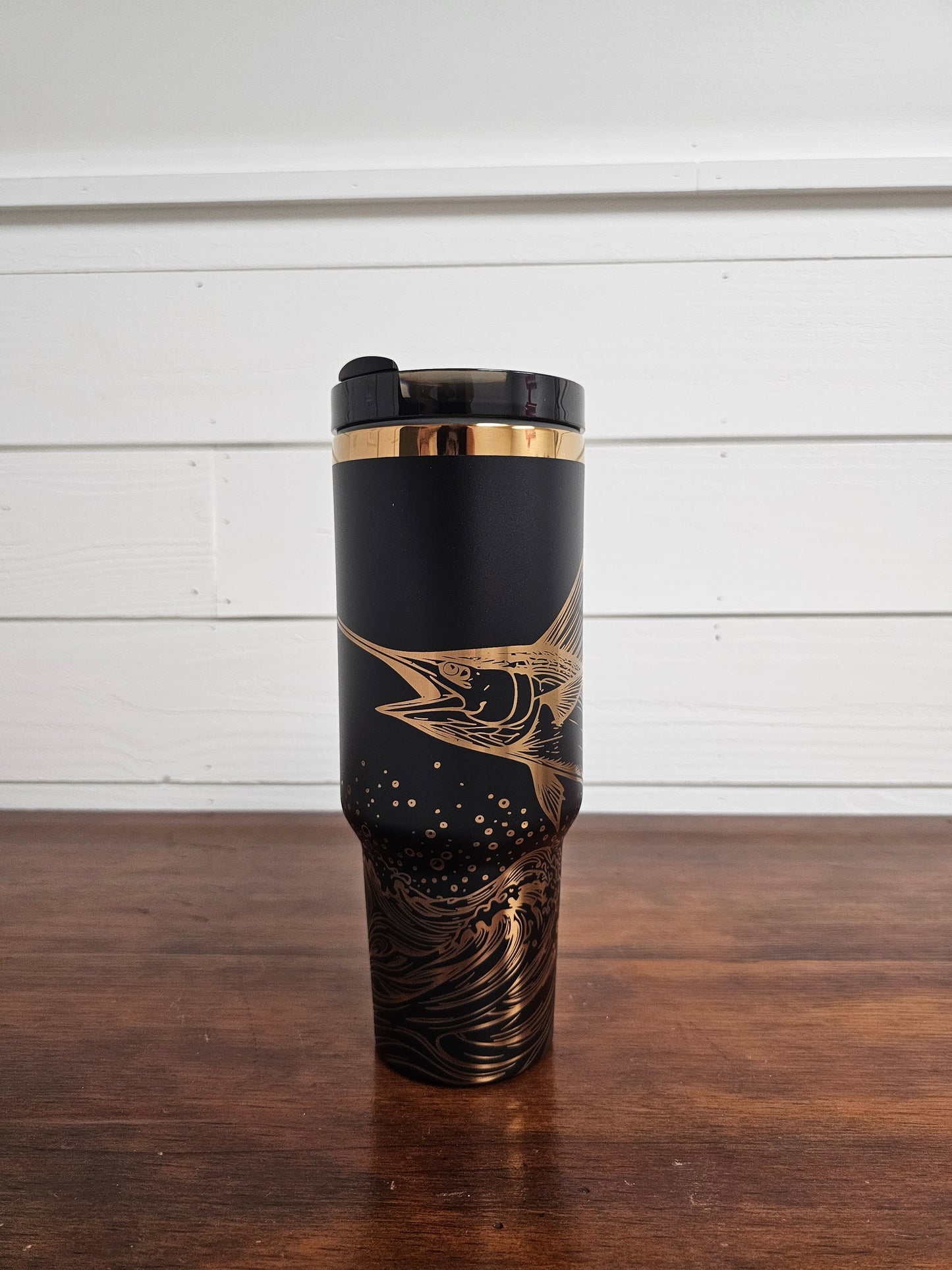 Laser engraved black and copper 40oz stainless steel tumbler with white marlin leaping out of the ocean.