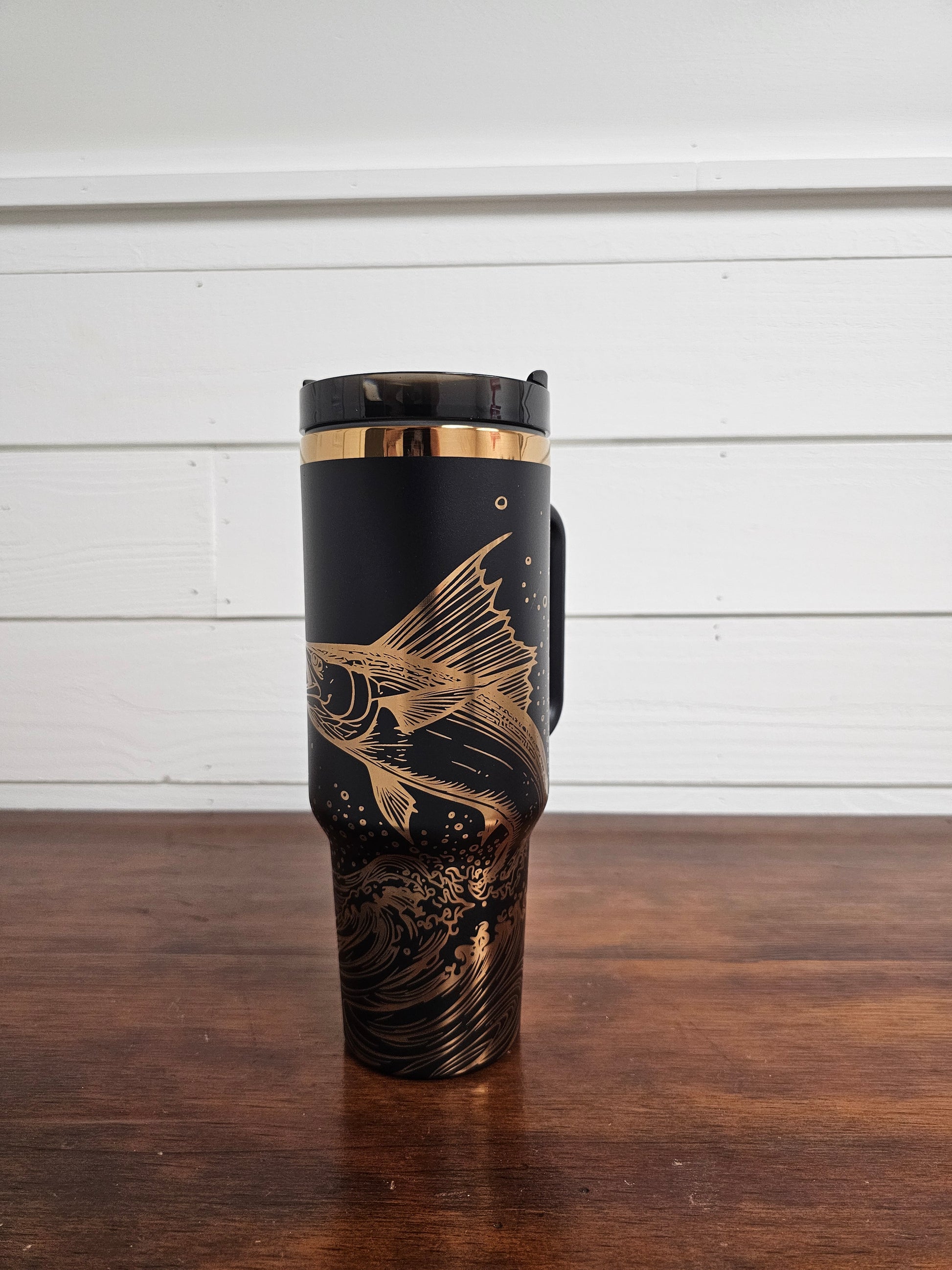 Laser engraved black and copper 40oz stainless steel tumbler with white marlin leaping out of the ocean.