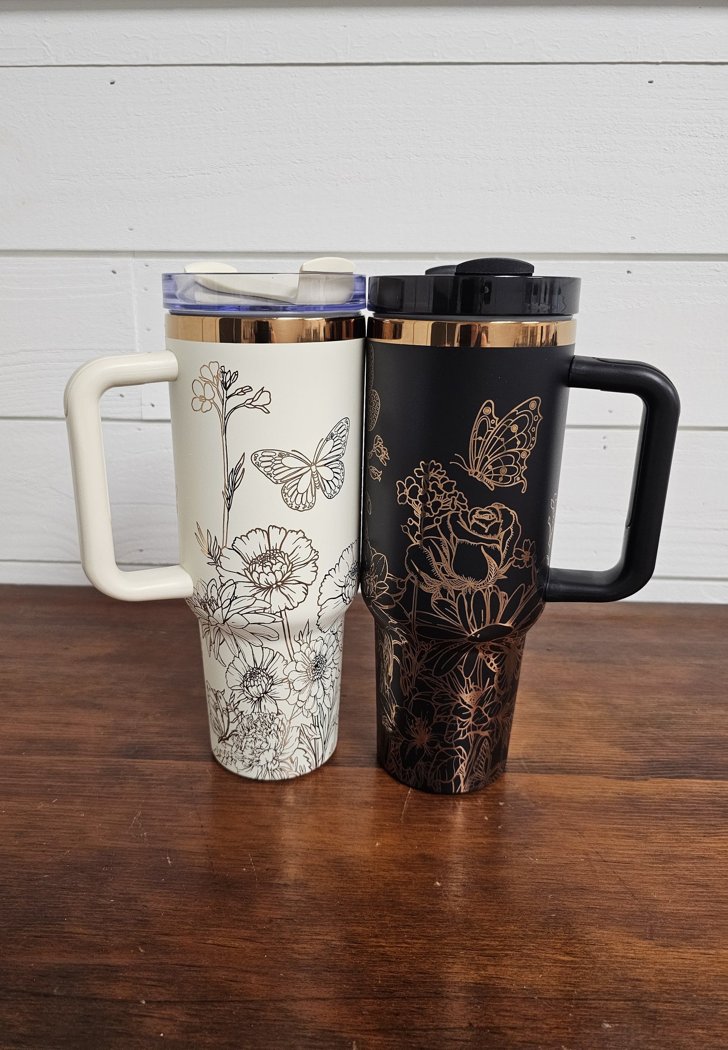 Cream and black with copper tumbler with floral and butterfly design on a white shiplap background