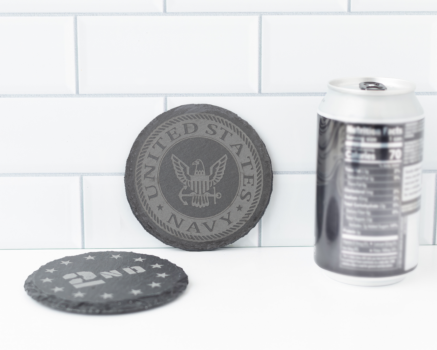 Two round coasters with 'United States Navy' design and '2nd' text on a tiled surface.