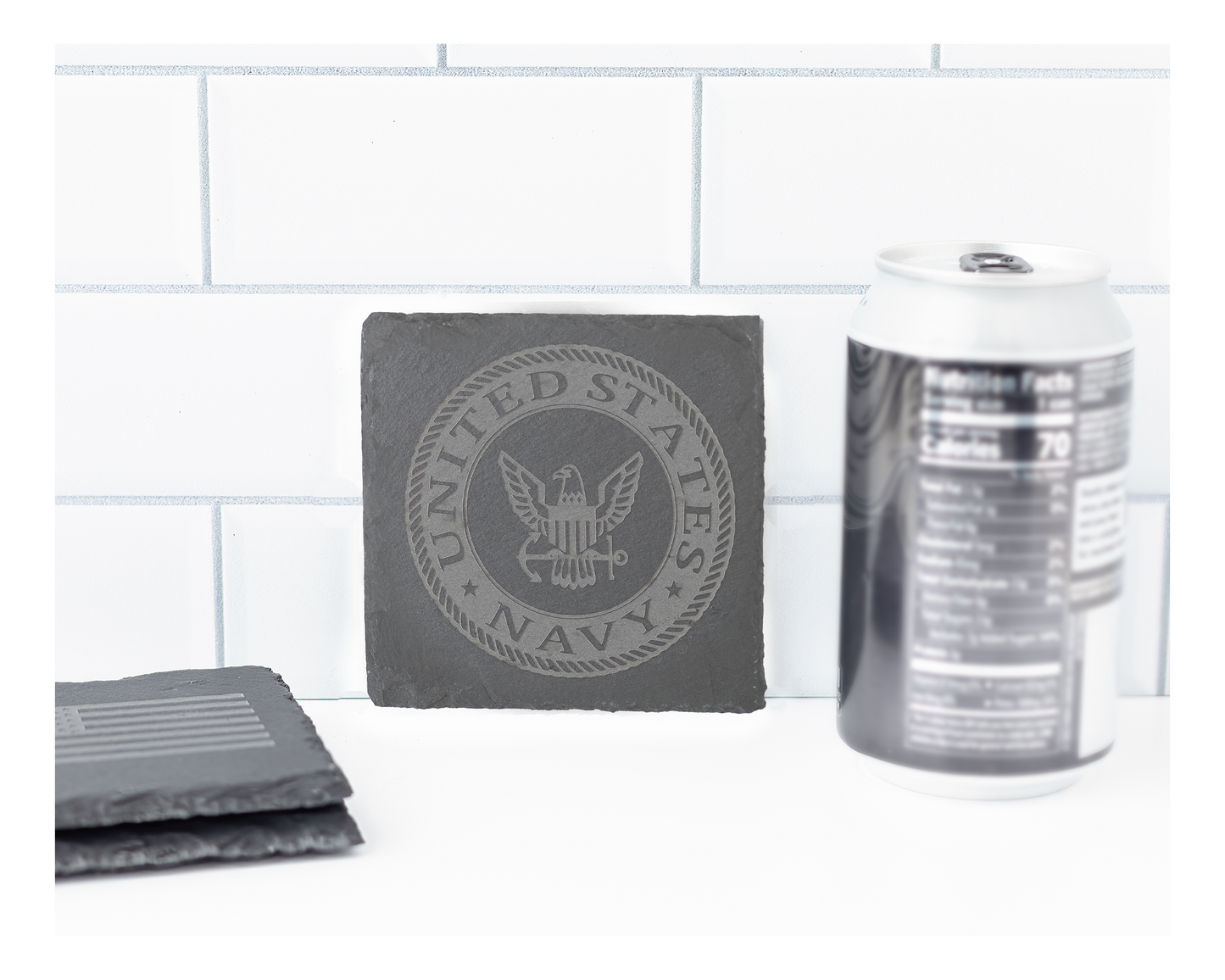 Gray coasters with U.S. Navy emblem on a white surface