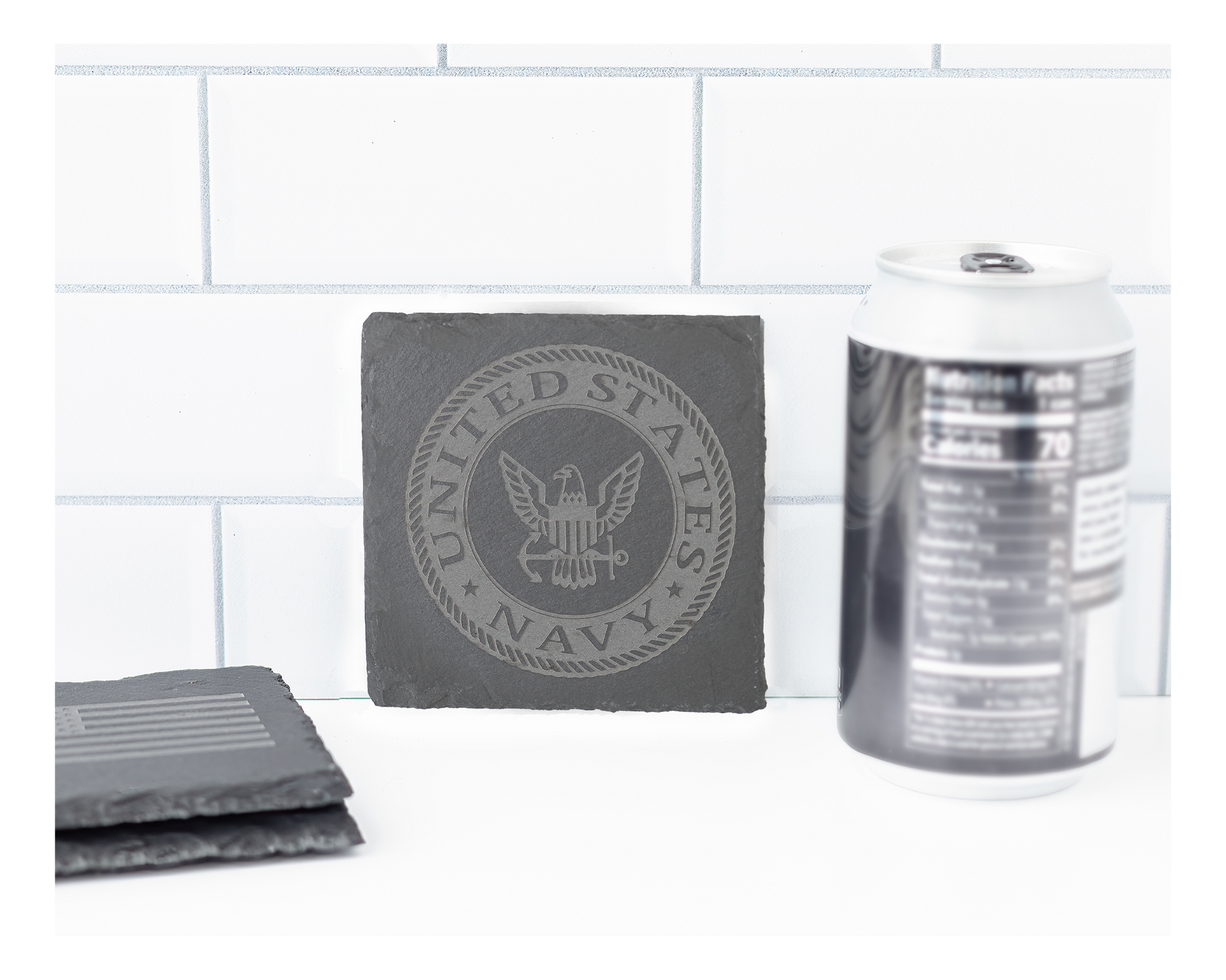 Gray coasters with U.S. Navy emblem on a white surface