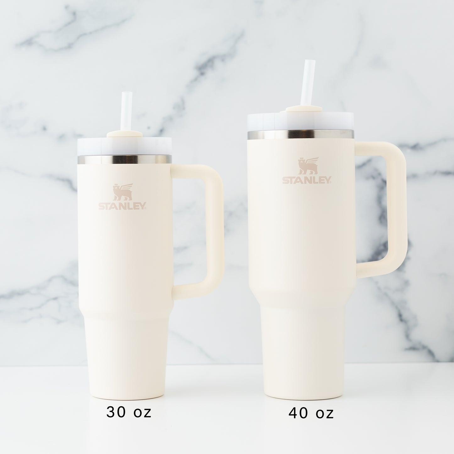 30oz and 40oz laser engraved Stanley tumblers in cream on a marbled background