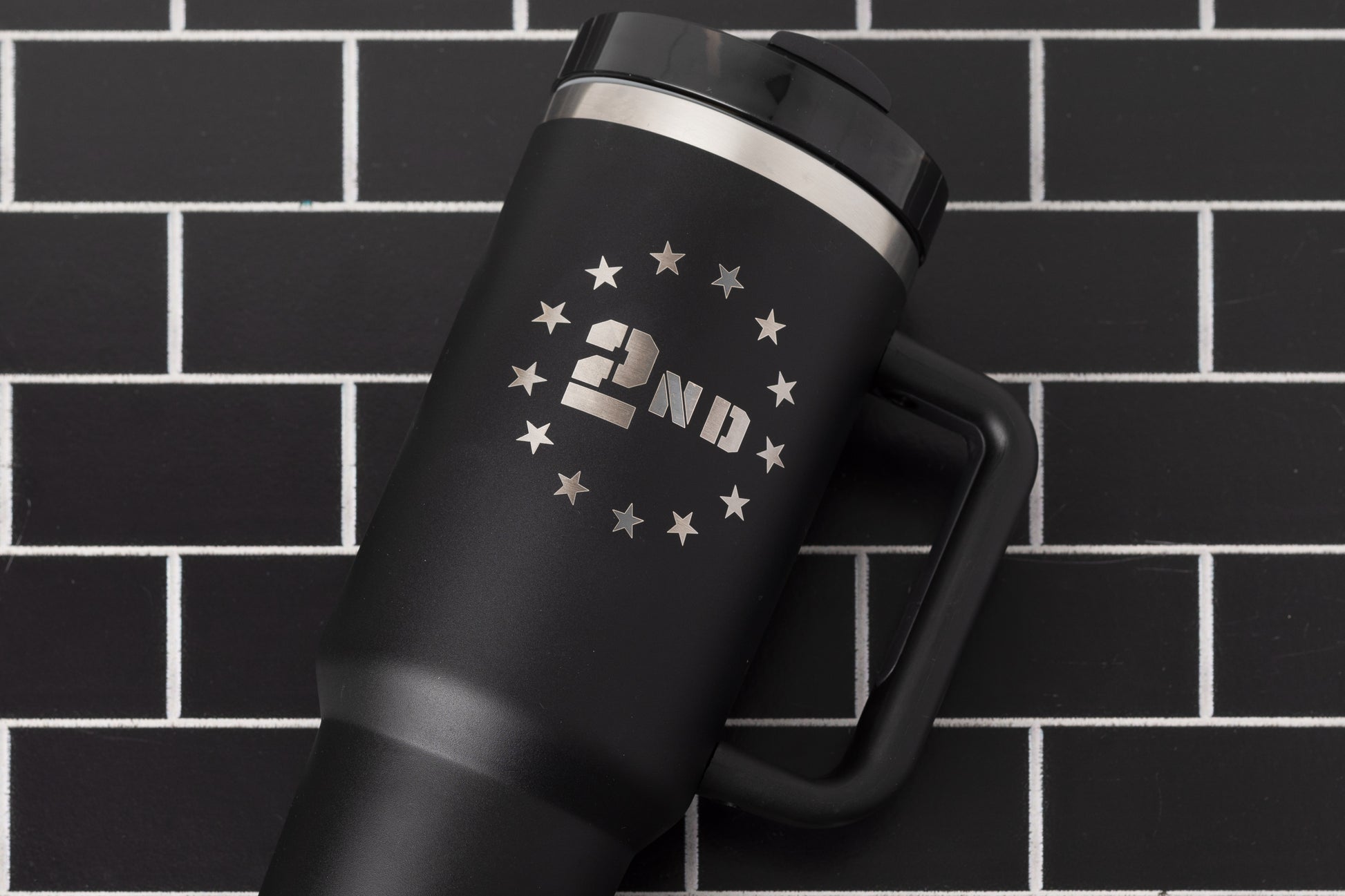 40oz tumbler in black with a 2nd Amendment design surrounded by stars. Flat lay.