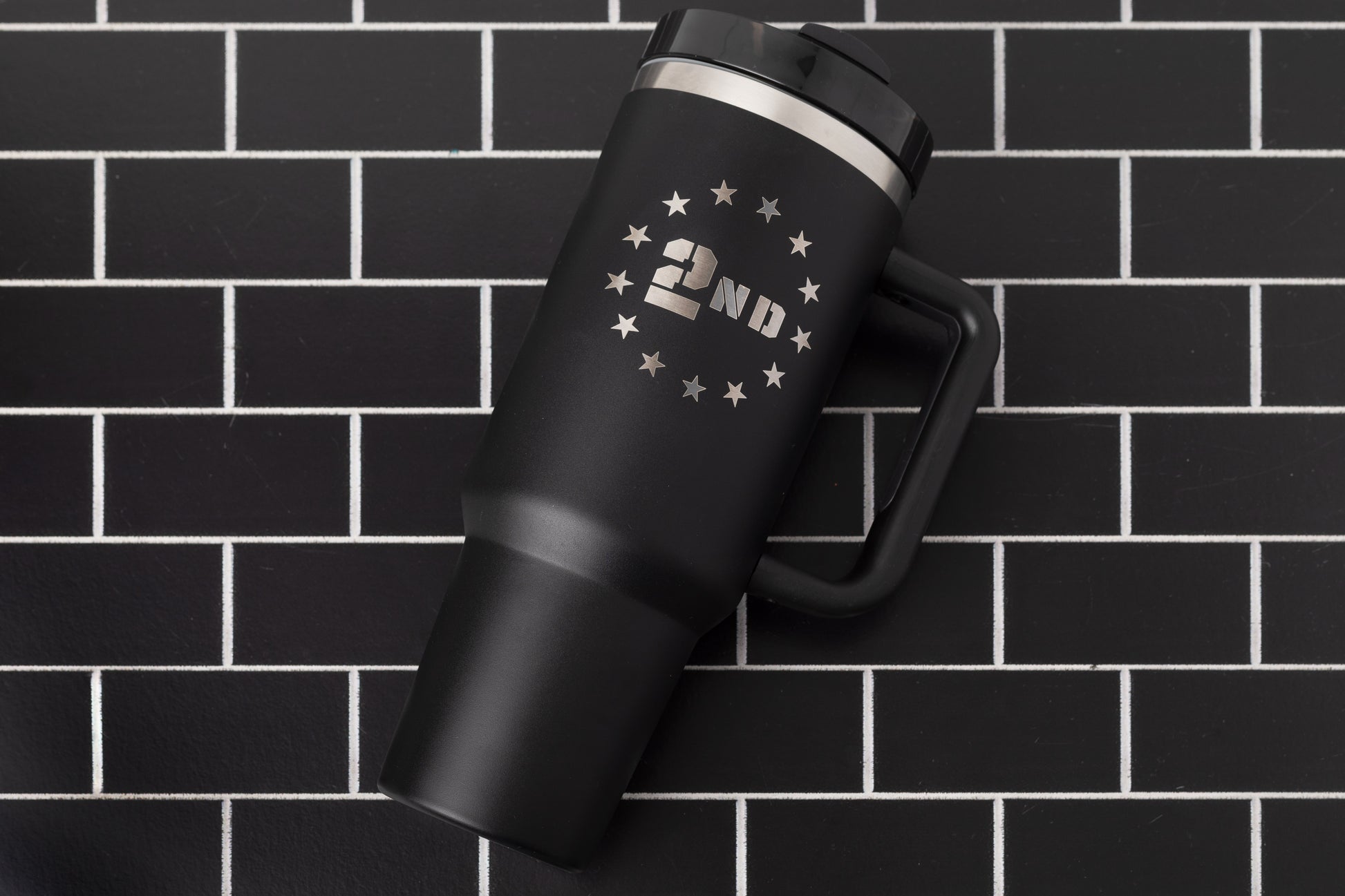 40oz tumbler in black with a 2nd Amendment design surrounded by stars. Flat lay.