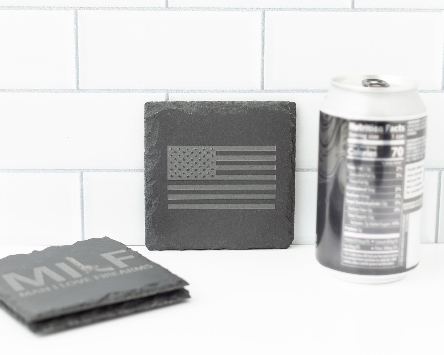 Slate coasters with American flag design and 'MILF' text on a white surface.