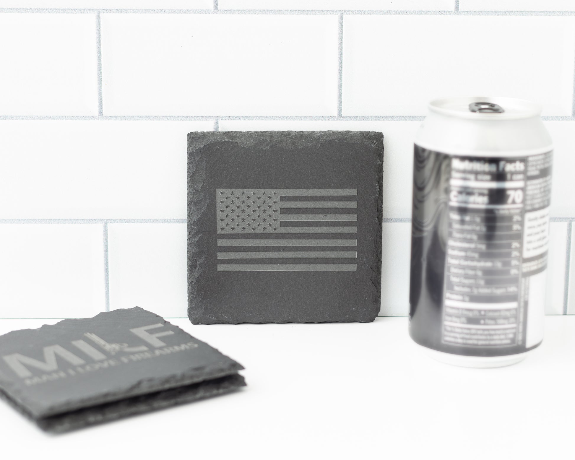 Slate coasters with American flag design and 'MILF' text on a white surface.