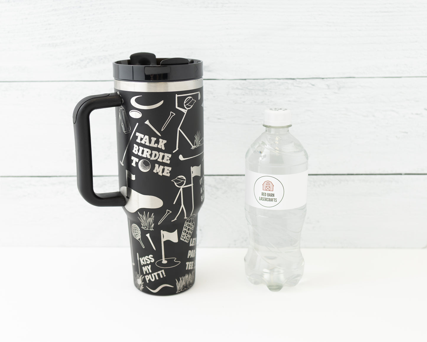 40 oz tumbler in black with golf funny sarcastic sayings and cartoon doodles wrapped around the tumbler. Front view next to a water bottle for size comparison.