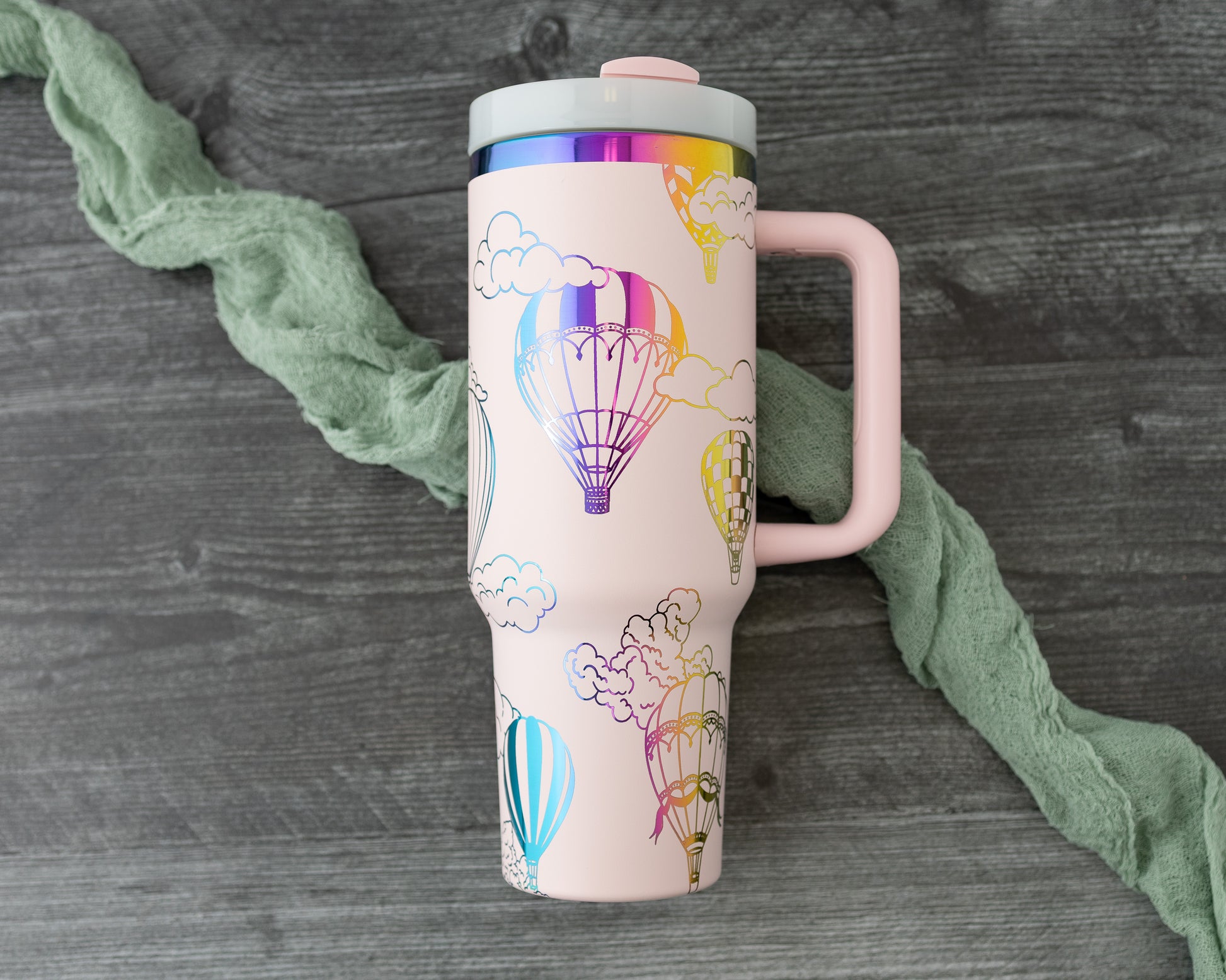 Laser engraved pink and rainbow 40oz stainless steel tumbler with hot air balloon and cloud design.