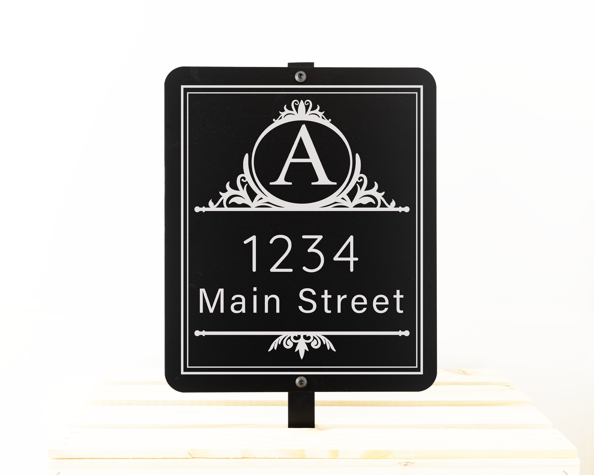 Black garden sign engraved with a decorative monogram and an address. Shown on a white background.
