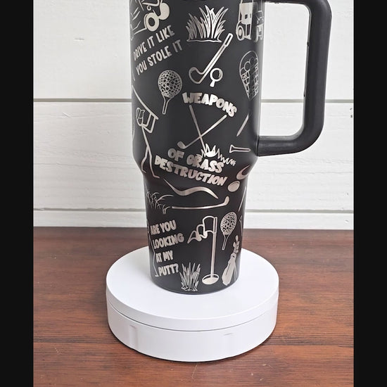 40 oz tumbler in black with golf sarcastic sayings and cartoon doodles wrapped around the tumbler. 